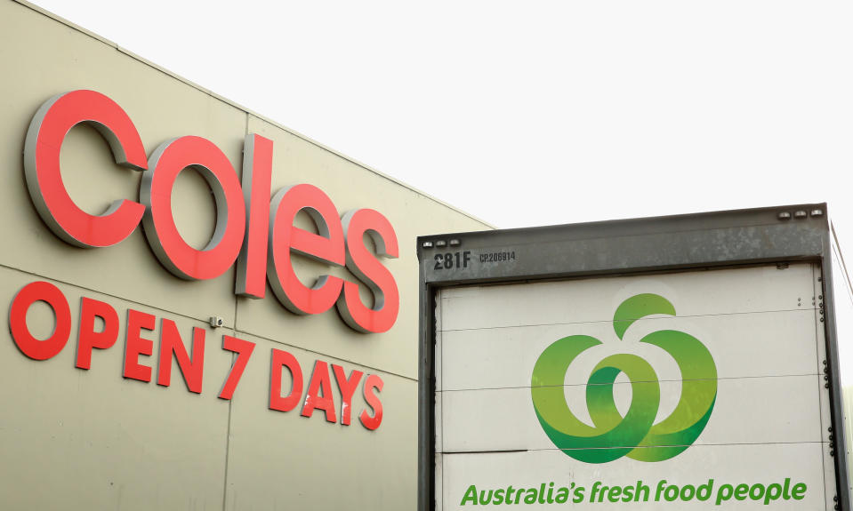 Picture shows a Woolworths truck outside a Coles store.