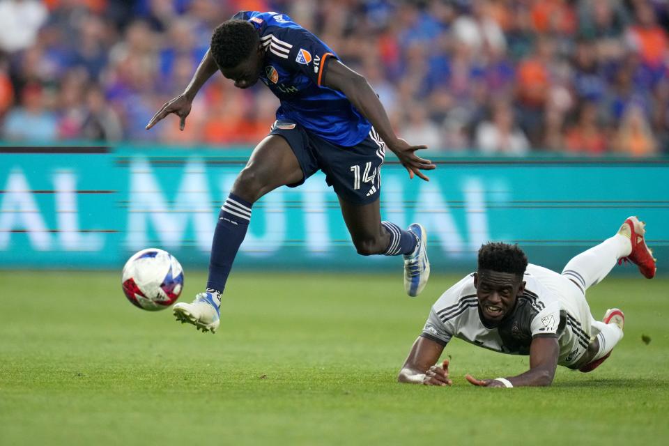 Avance del FC Cincinnati Dominique Badji (14) vence al defensor del Toronto FC Aimé  Mabika (6) en una carrera por un gol en la segunda mitad de un partido de fútbol de la MLS entre Toronto FC y FC Cincinnati, el miércoles 21 de junio de 2023, en el estadio TQL de Cincinnati. 