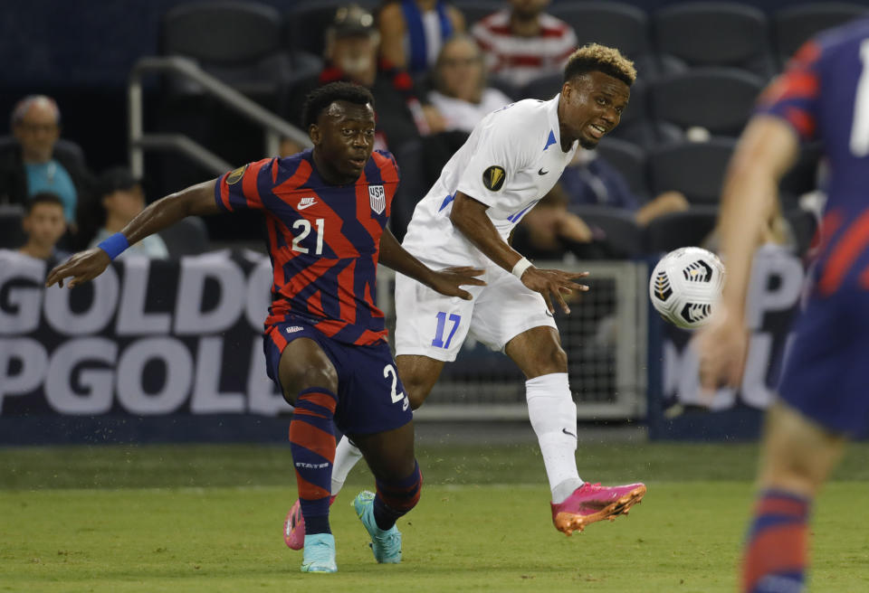 Martinique's Patrick Burner (17) clears the ball as United States' George Bello (21) pressures during the first half of a CONCACAF Gold Cup soccer match in Kansas City, Kan., Thursday, July 15, 2021. (AP Photo/Colin E. Braley)