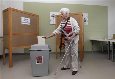 A woman casts her vote at a polling station during an early general election in Slavkov u Brna October 25, 2013. REUTERS/David W Cerny