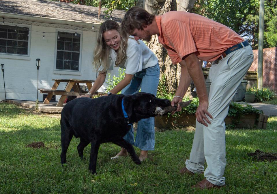 Chad Matthews and Jill Bridges play with their dog, Bleu, in their backyard in Gallatin, Tenn., Tuesday, Aug. 29, 2023. Bridges and Matthew wanted a home that had a big backyard for their dog.