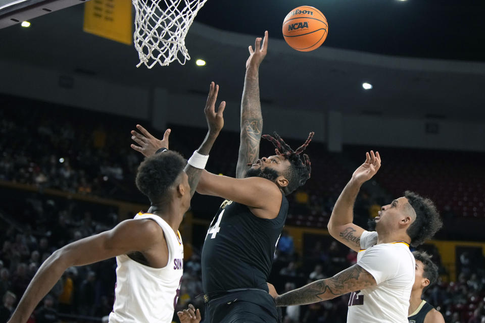 Colorado center Eddie Lampkin Jr., center, shoots between Arizona State forward Alonzo Gaffney, left, and guard Jose Perez, front right, during the first half of an NCAA college basketball game, Saturday, Jan. 6, 2024, in Tempe, Ariz. (AP Photo/Rick Scuteri)