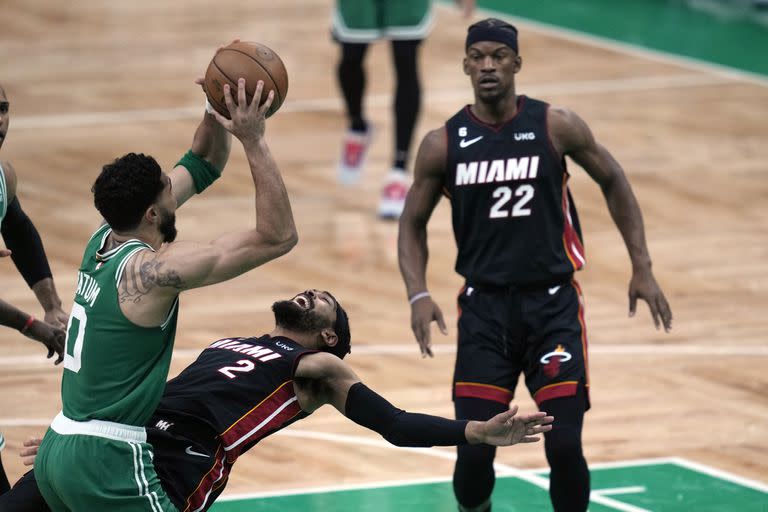 Jayson Tatum lanza al aro mientras Gabe Vincent cae y Jimmy Butler observa