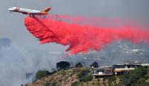 Firefighters battle a blaze from the air that was threatening homes in the Pacific Palisades community of Los Angeles, California, U.S.