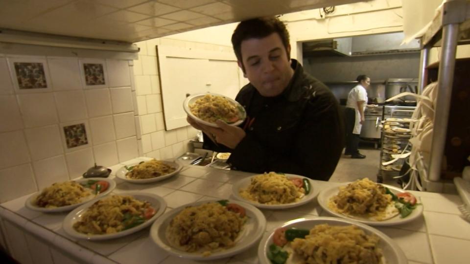 Adam Richman staring down a bunch of breakfast tacos