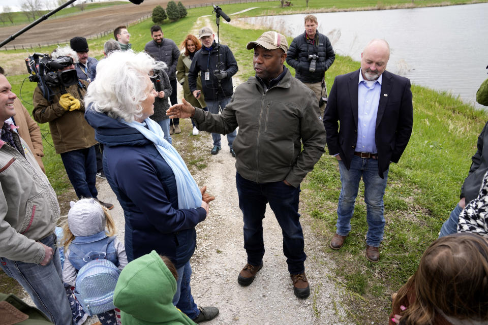 Sen. Tim Scott, R-S.C., center, talks with Linda Juckette, center left, as he tours her farm Saturday, April 22, 2023, in Cumming, Iowa. (AP Photo/Charlie Neibergall)