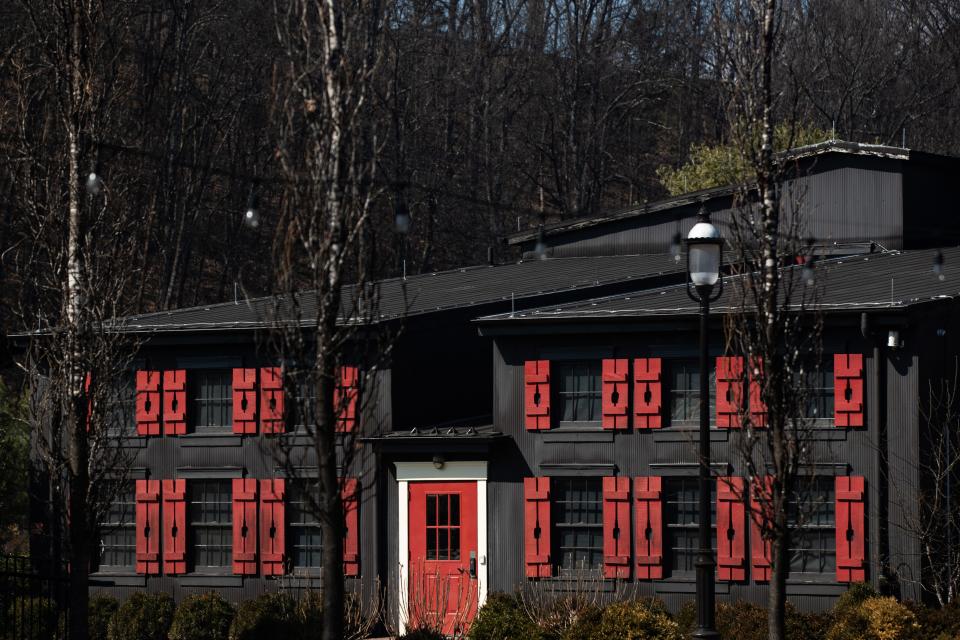 Red shutters with a Maker's Mark bottle silhouette cutout flank the windows of a building at the Maker's Mark distillery in Loretto, Kentucky. March 3, 2022