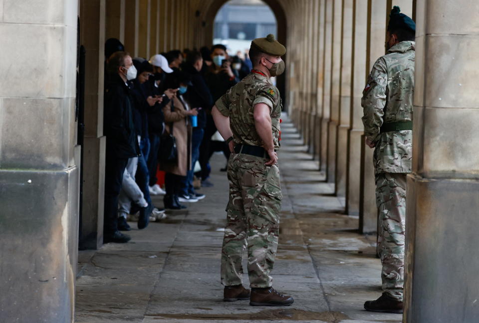 Soldiers stand outside a vaccination centre, while people queue to receive COVID-19 vaccine and booster doses, as the spread of the coronavirus disease (COVID-19) continues, in Manchester, Britain, December 14, 2021. REUTERS/Phil Noble