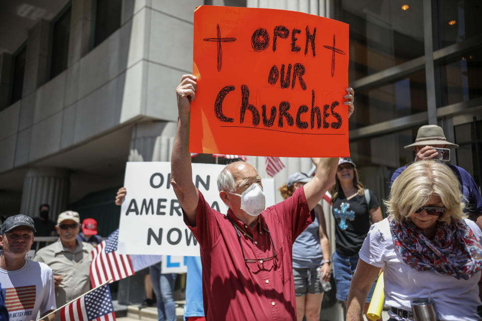 Demonstrators hold signs on May 1 during a rally in San Diego against California's stay-at-home directives. (Photo: SANDY HUFFAKER via Getty Images)