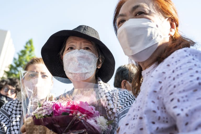 Japan’s Red Army founder Fusako Shigenobu (C) meets the media after her release from jail, flanked by her daughter May Shigenobu (L) and her lawyer (R) in Akishima, in Tokyo on May 28, 2022. (Photo by Charly TRIBALLEAU / AFP)