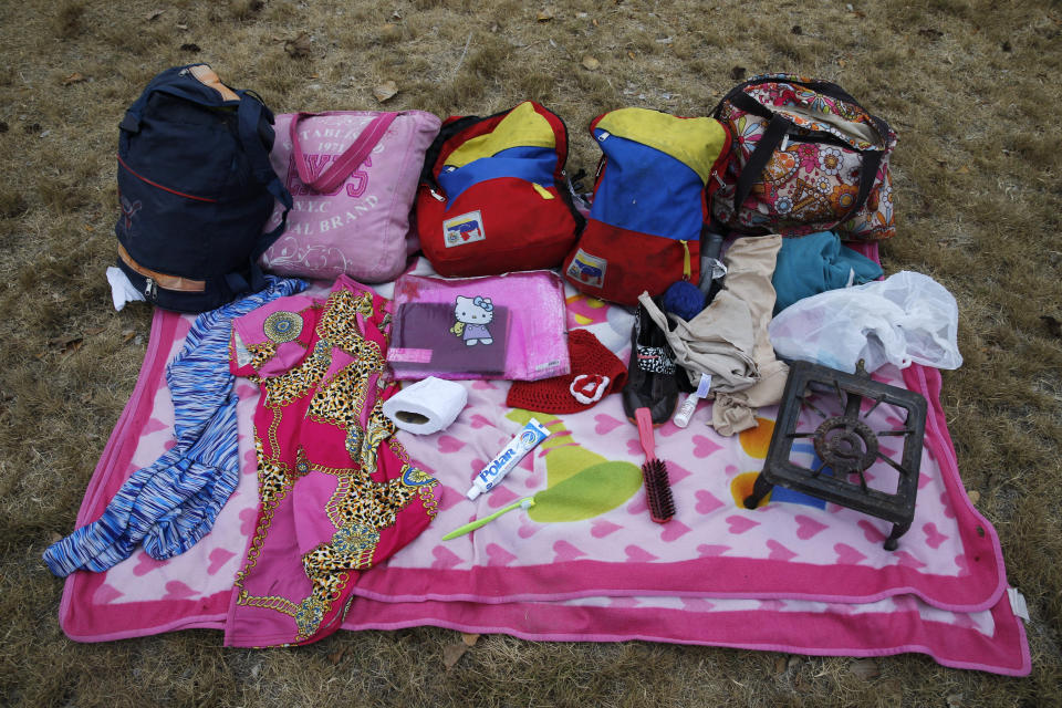 En esta imagen, tomada el 7 de septiembre de 2018, las pertenencias con las que la venezolana Sandra Cádiz y su hija Angelis, de 10 años, viajaron a pie desde su país a Perú, dispuestas una fotografía en Huaquillas, Ecuador. Llevaban ropa vieja, zapatos, un cepillo con las cerdas torcidas y un rollo de papel sanitario aplastado. Tenían también una pesada y vieja hornilla de gas que una hermana de Cádiz insistió en que debían llevar a una sobrina en Lima. (AP Foto/Ariana Cubillos)