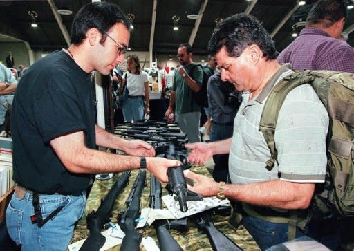 File photo shows a US gun salesman demonstrating a semi-automatic weapon to a potential customer in California. Experts say that in the regions of US states that run along the Mexican border there are some 9,000 gun stores