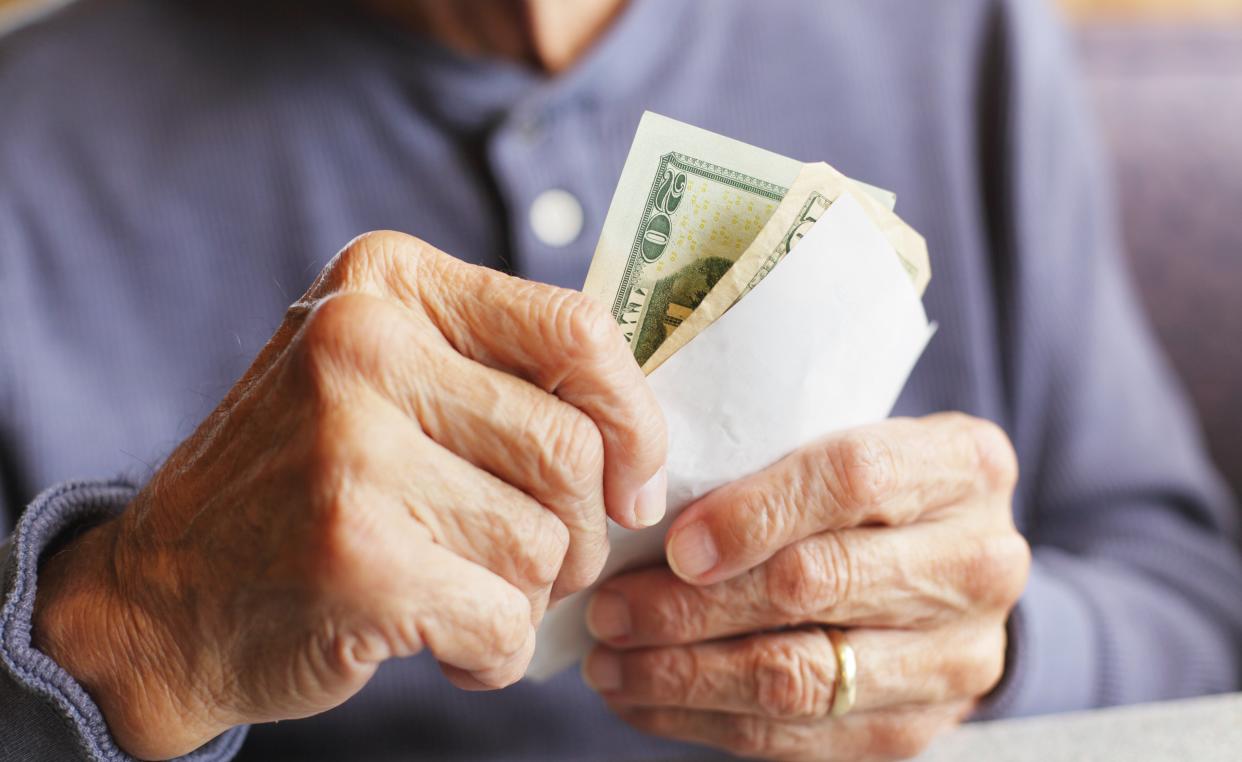 older man removing cash from an envelope