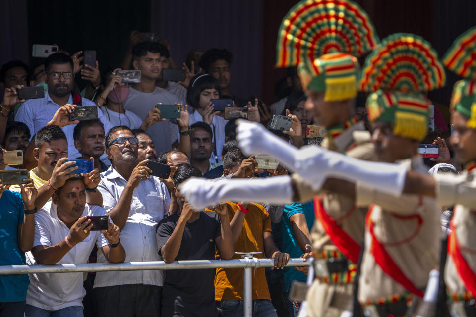 People take photographs on their mobile phones as Assam police battalion personnel take part in the parade on Independence Day in Gauhati, in the northeastern state of Assam, India, Monday, Aug. 15, 2022. The country is marking the 75th anniversary of its independence from British rule. (AP Photo/Anupam Nath)