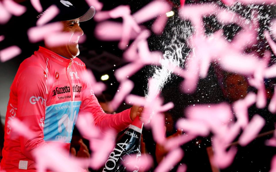 Richard Carapaz celebrates on the podium in Courmayeur after taking the leader's jersey at the Giro - AFP or licensors