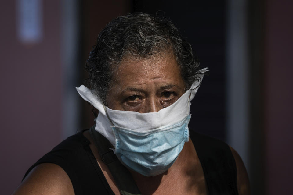 A woman wearing a face mask to prevent the spread of the coronavirus walks in the southern neighbourhood of Vallecas in Madrid, Spain, Monday, Sept. 21, 2020. Police in the Spanish capital and its surrounding towns are stopping people coming in and out of working-class neighborhoods that have been partially locked down to stem Europe's fastest coronavirus spread. (AP Photo/Bernat Armangue)