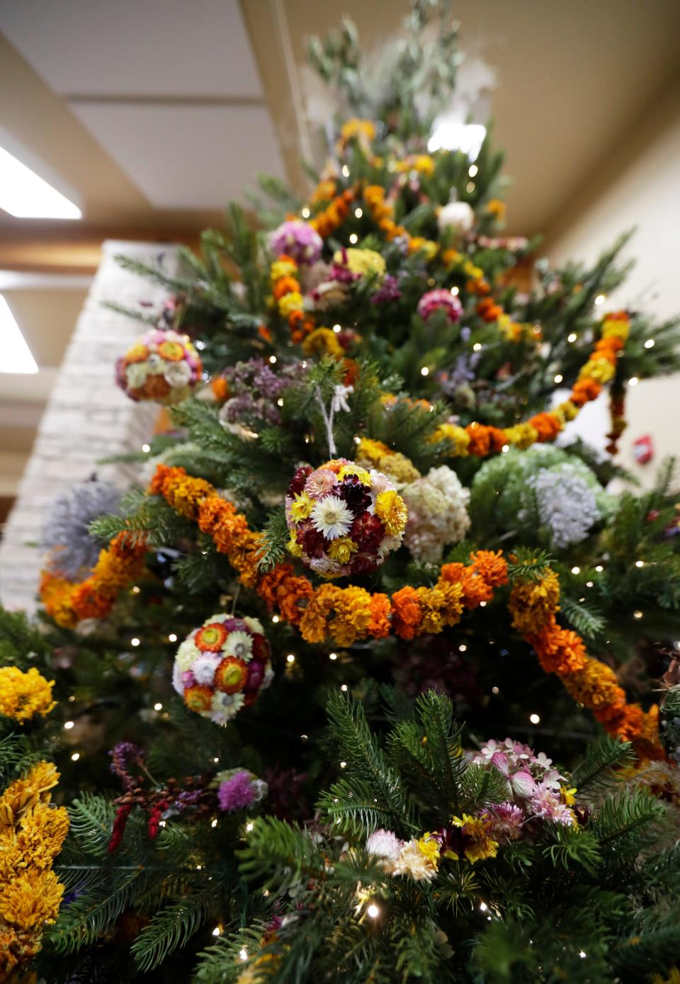 A towering 12-foot tree inside the Fischer Visitor Center at Green Bay Botanical Garden is decorated with ornaments and garland made entirely from dried flowers, seed pods and other natural elements.