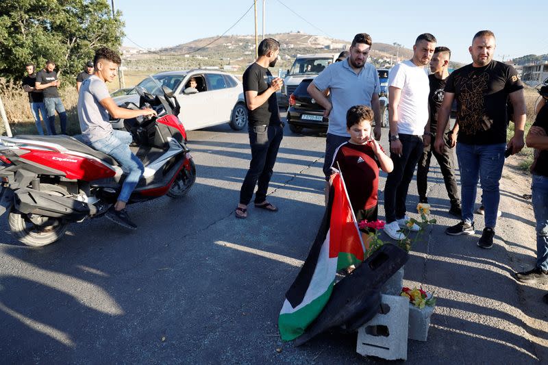 Palestinians gather at a scene where Israeli forces targeted a Palestinian car, near Jenin
