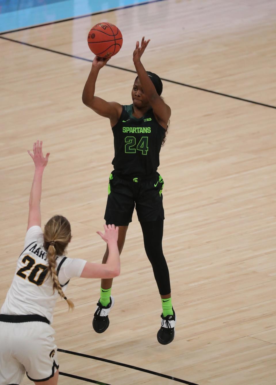 Michigan State guard Nia Clouden (24) scores against Iowa guard Kate Martin (20) during the Big Ten tournament Friday, March 12, 2021, at Bankers Life Fieldhouse in Indianapolis.