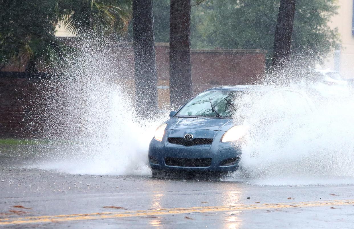 A car drives through a flooded portion of Northwest Millhopper Road. The Alachua County area has a 30% chance of a tropical depression forming, according to the National Weather Service.