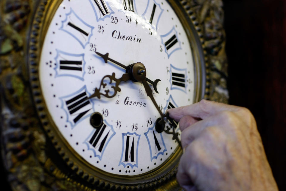 Howie Brown adjusts the time on a clock back one hour for the end of daylight saving time at Brown's Old Time Clock Shop, Nov. 2, 2007, in Plantation, Florida. / Credit: Joe Raedle/Getty Images