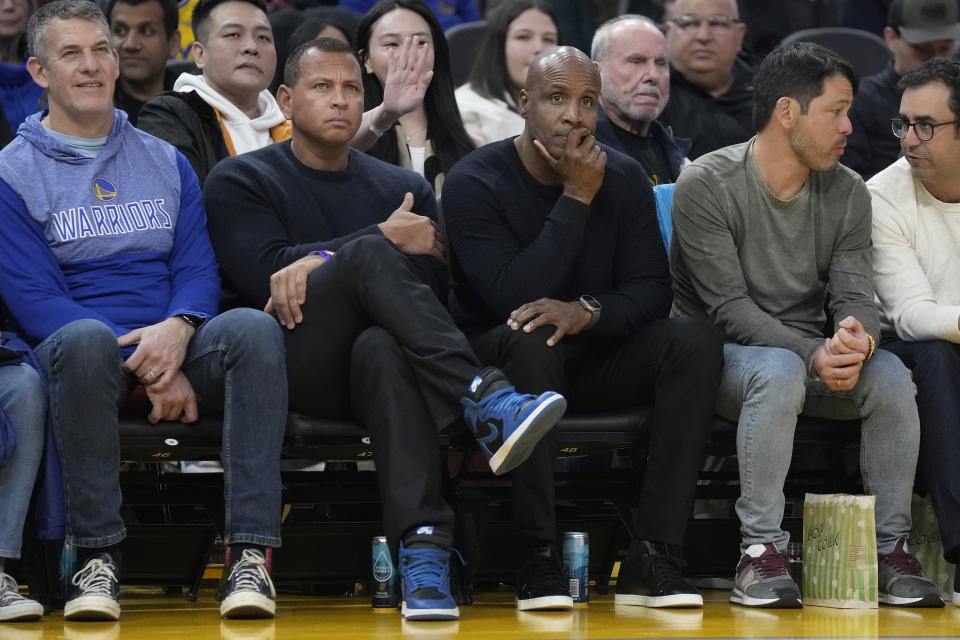 Minnesota Timberwolves co-owner Alex Rodriguez, middle left, and former baseball player Barry Bonds, middle right, watch during the first half of an NBA basketball game between the Golden State Warriors and the Timberwolves in San Francisco, Sunday, Feb. 26, 2023. (AP Photo/Jeff Chiu)