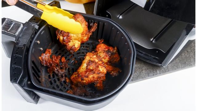 Una moderna freidora eléctrica con patatas fritas y zumo de naranja natural  en la cocina ai generative