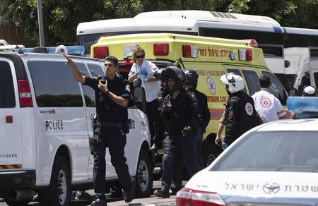 Israeli police officers and medics stand next to an ambulance carrying a wounded Israeli border policewoman outside a checkpoint near the West Bank town of Bethlehem, after a stabbing attack June 29, 2015. REUTERS/Ronen Zvulun