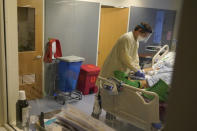 Clinical Nurse Zachary Petterson tends to a COVID-19 patient in the intensive care unit at Santa Clara Valley Medical Center during the coronavirus pandemic in San Jose, Calif., Wednesday, Jan. 13, 2021. (AP Photo/Jeff Chiu)