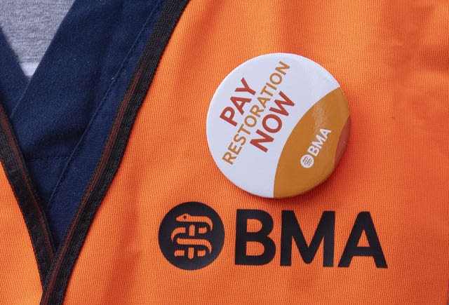 A BMA badge that says the words 'pay restoration now' attached to a BMA hi-vis jacket