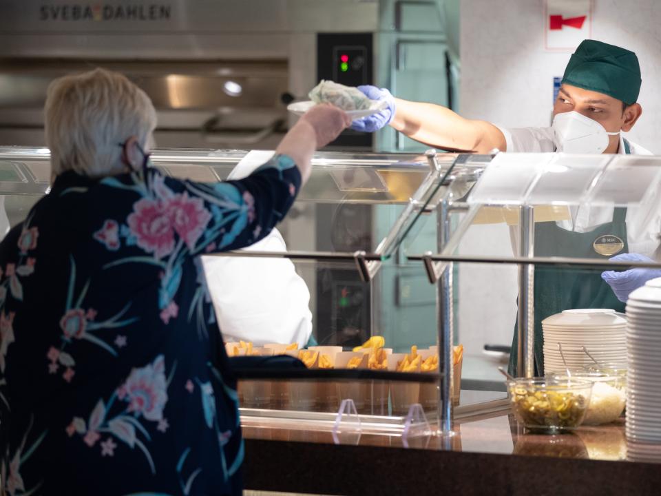 Guests are served food in the Marketplace buffet onboard the cruise ship MSC Virtuosa.