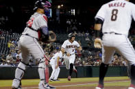 Arizona Diamondbacks' Josh Rojas scores on a double by Ketel Marte as Atlanta Braves catcher William Contreras, left, waits for the throw during the third inning of a baseball game, Monday, Sept. 20, 2021, in Phoenix. (AP Photo/Matt York)