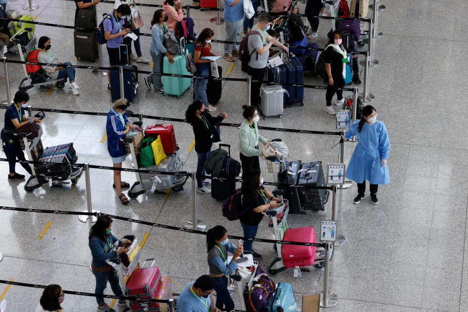 Travellers queue up for shuttle bus to quarantine hotels at the Hong Kong International Airport, amid the coronavirus disease (COVID-19) pandemic, in Hong Kong, China, August 1, 2022. REUTERS/Tyrone Siu