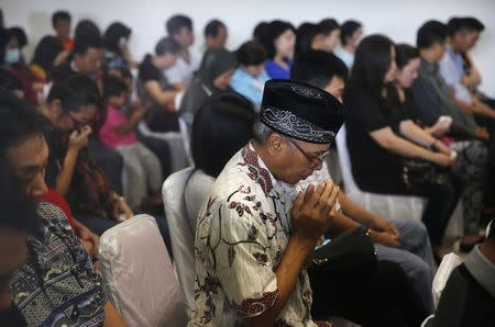 Relatives of passengers onboard AirAsia flight QZ8501 pray together in a waiting area at Juanda International Airport in Surabaya December 29, 2014. REUTERS/Beawiharta