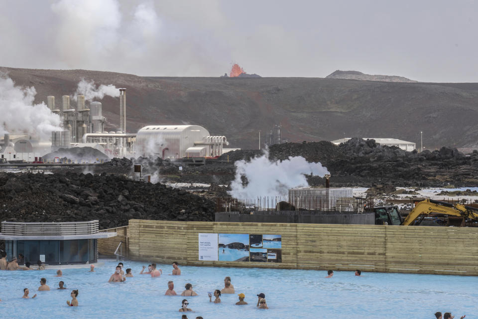 The Blue Lagoon with people bathing in it as the volcanic crater spews lava in the background in Grindavik, Iceland, Sunday, June 2, 2024. The popular Blue Lagoon geothermal spa, one of Iceland’s biggest tourist attractions in the country's southwest, was reopened Sunday after authorities said a nearby volcano had stabilized after erupting four days earlier. (AP Photo/Marco di Marco)