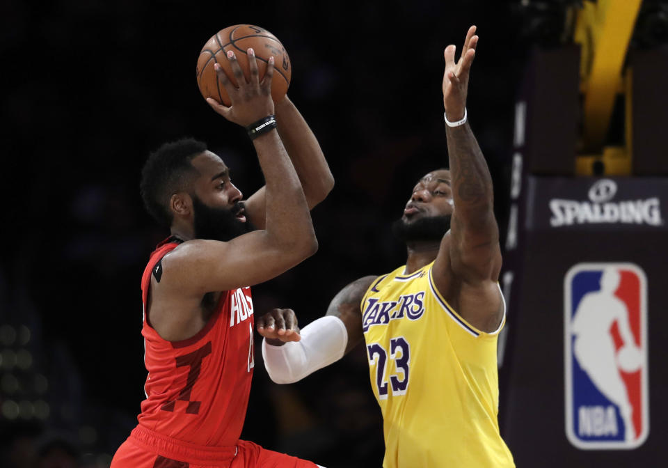 Houston Rockets' James Harden, left, passes the ball next to Los Angeles Lakers' LeBron James during the first half of an NBA basketball game Thursday, Feb. 21, 2019, in Los Angeles. (AP Photo/Marcio Jose Sanchez)