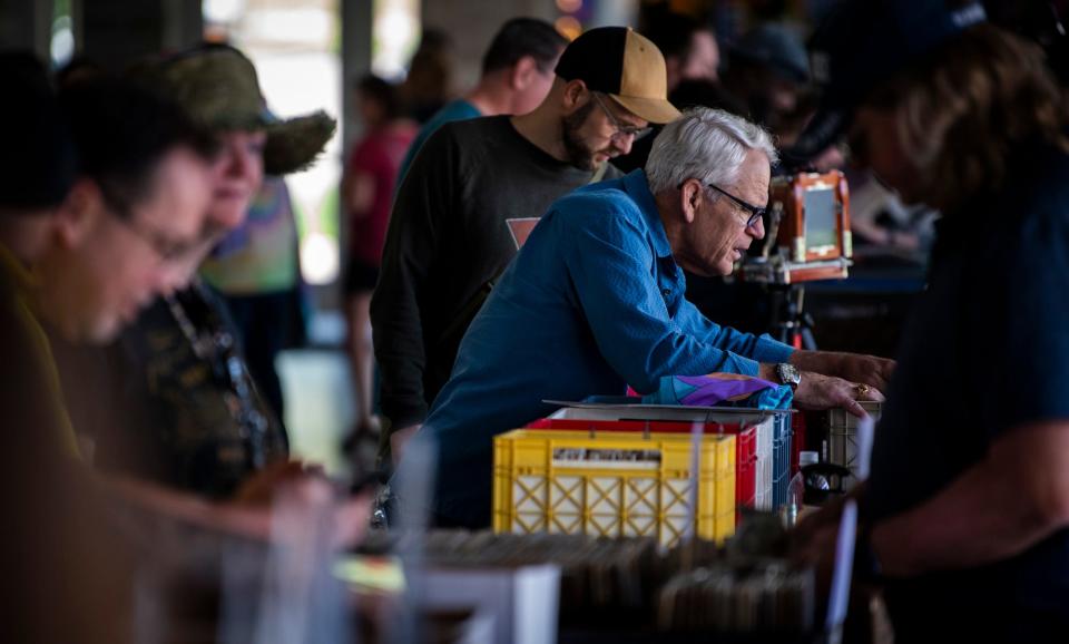 Mark Melcher looks through vinyl records at the Bloomington Music Expo at Switchyard Park Pavilion on Saturday, May 20, 2023.