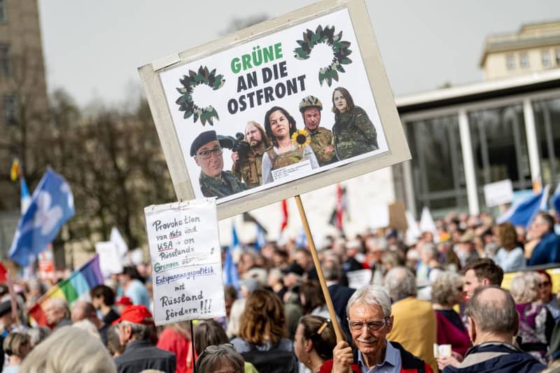 People with a sign reading "Greens to the Eastern Front" take part in the traditional Easter march under the slogan "Warlike - Never Again". Fabian Sommer/dpa