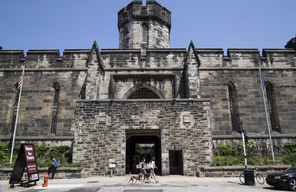 People walk past the Eastern State Penitentiary, Thursday, May 2, 2019, which is now a museum, in Philadelphia. The historic site has made a recreation of gangster Al Capone's 1929 cell. (AP Photo/Matt Rourke)