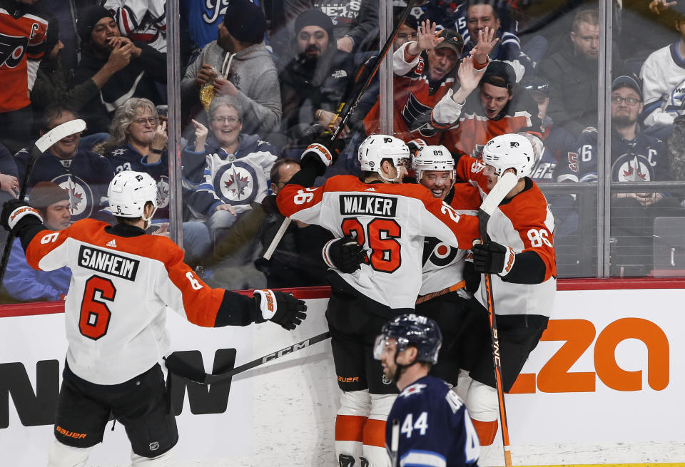 Philadelphia Flyers' Travis Sanheim (6), Sean Walker (26), Cam Atkinson (89) and Joel Farabee (86) celebrate Atkinson's goal against the Winnipeg Jets during the first period of an NHL hockey game in Winnipeg, Manitoba, Saturday, Jan. 13, 2024. (John Woods/The Canadian Press via AP)