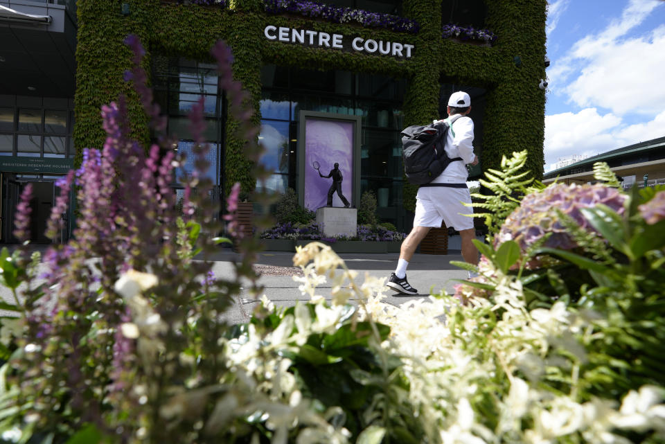 A man walks past the statue to former Wimbledon champion Fred Perry ahead of the Wimbledon tennis championships in London, Sunday, June 26, 2022. (AP Photo/Kirsty Wigglesworth)