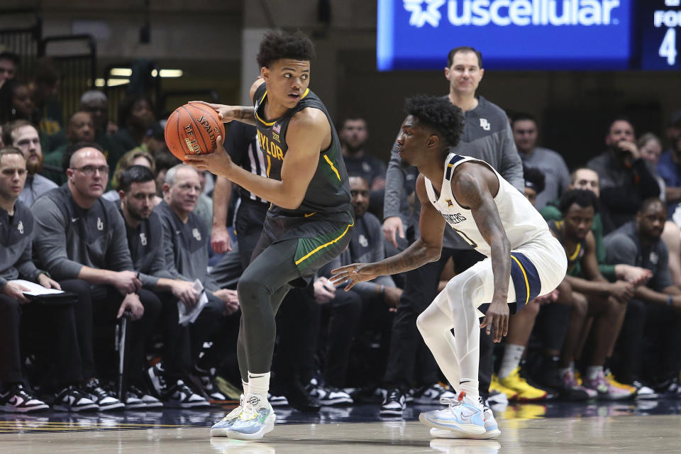 Baylor guard Keyonte George (1) is defended by West Virginia guard Kedrian Johnson (0) during the second half of an NCAA college basketball game in Morgantown, W.Va., Wednesday, Jan. 11, 2023. (AP Photo/Kathleen Batten)