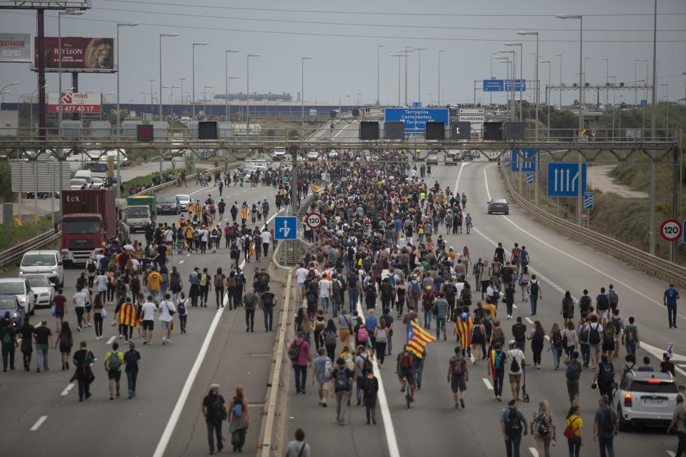 In this Monday, Oct. 14, 2019 photo, pro-independence protesters march towards El Prat airport, outskirts of Barcelona, Spain. Riot police engaged in a running battle with angry protesters outside Barcelona's airport Monday after Spain's Supreme Court convicted 12 separatist leaders of illegally promoting the wealthy Catalonia region's independence and sentenced nine of them to prison. (AP Photo/Joan Mateu)