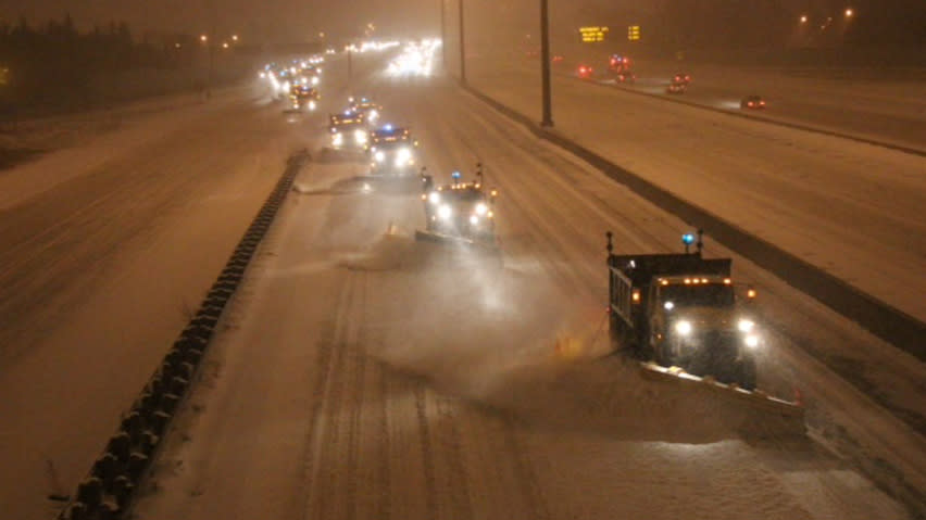 Snowplows clear snow on Highway 401 at Avenue Road in Toronto early Thursday due to the first heavy snowfall of the season in Ontario and Quebec.