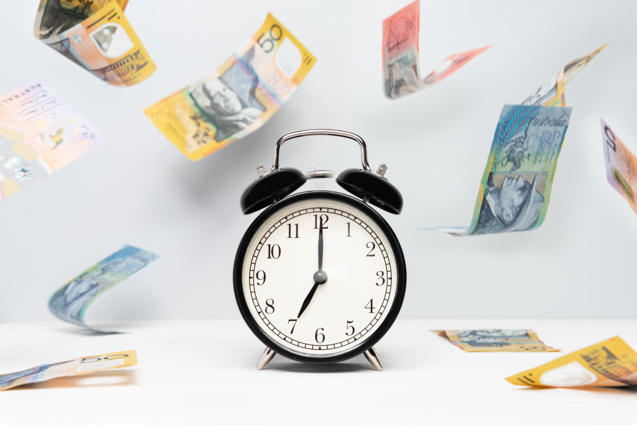 Clock and Australian money on light color background. Time is Money. Tax season concept.