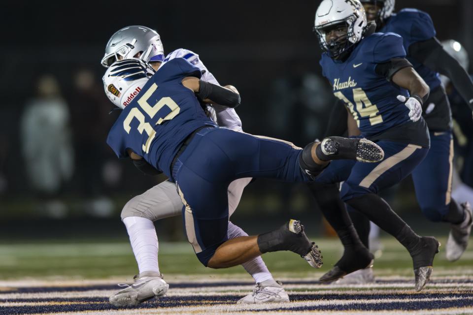 Bloomington South High School senior Jarrin Alley (12) is hit by Decatur High School senior Halbert Aguirre (35) during the first half of an IHSAA Class 5A Semi-State football game, Friday, Nov. 17, 2023, at Decatur Central High School.