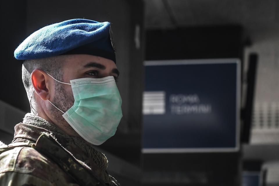 A soldier wearing a respiratory mask supervises platform access at the Termini railway station in Rome on March 10, 2020. - Italy imposed unprecedented national restrictions on its 60 million people on March 10, 2020 to control the deadly coronavirus, as China signalled major progress in its own battle against the global epidemic. (Photo by Tiziana FABI / AFP) (Photo by TIZIANA FABI/AFP via Getty Images)