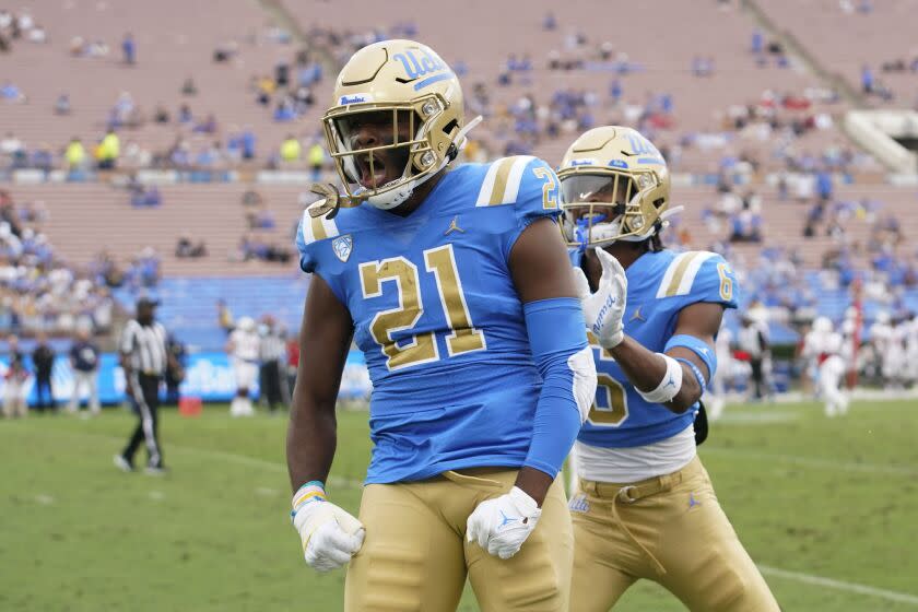 UCLA linebacker JonJon Vaughns (21) celebrates with UCLA defensive back John Humphrey.