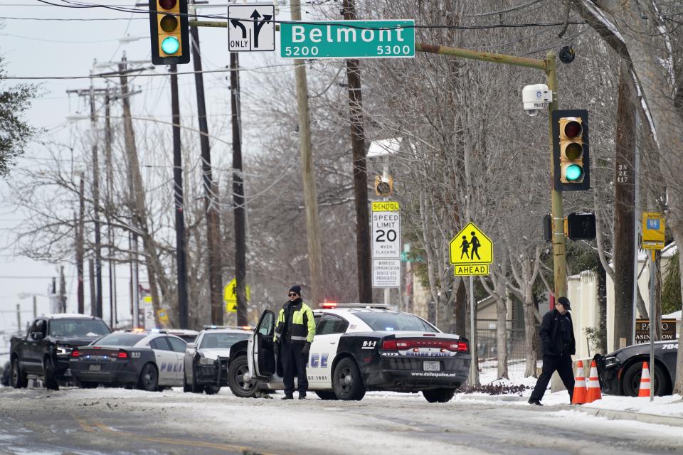 A Dallas police presence is seen at the street intersection of Belmont and Henderson in a neighborhood where earlier in the day two other officers were shot responding to an emergency call in Dallas, Thursday, Feb. 18, 2021. (AP Photo/Tony Gutierrez)