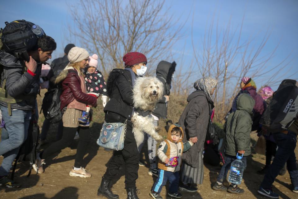 Migrants walk to reach Pazarakule border gate, Edirne, Turkey, at the Turkish-Greek border on Sunday, March 1, 2020. The United Nations migration organization said Sunday that at least 13,000 people were massed on Turkey's land border with Greece, after Turkey officially declared its western borders were open to migrants and refugees hoping to head into the European Union. (AP Photo/Emre Tazegul)